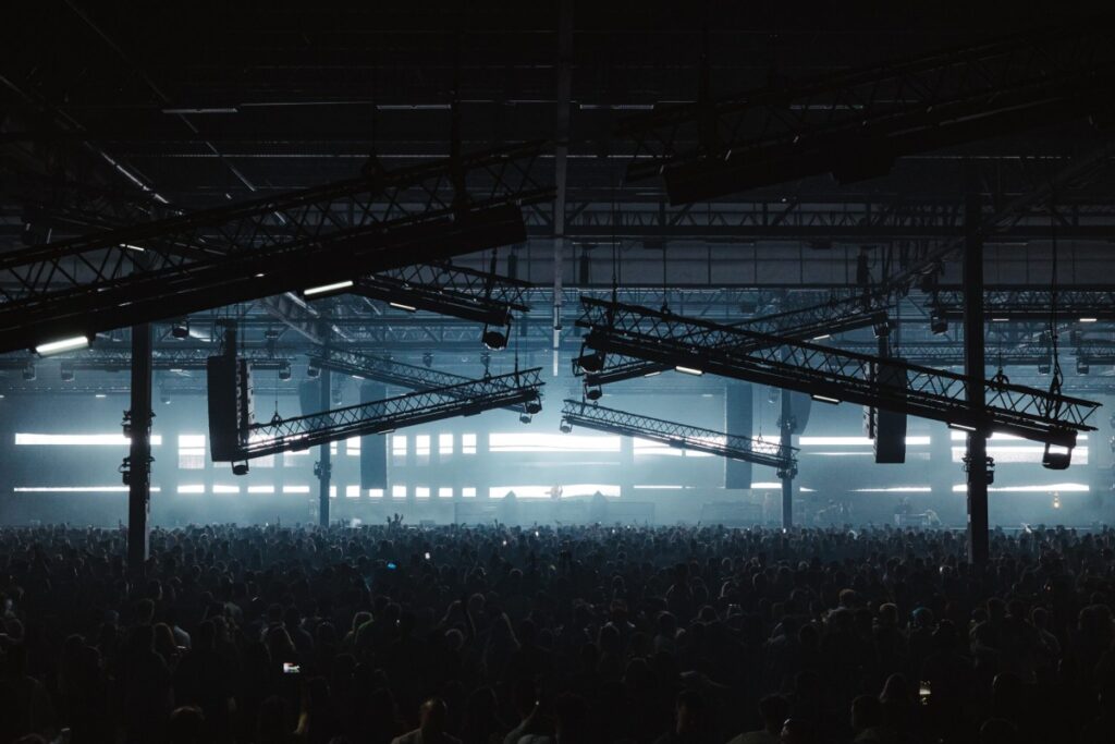 Packed warehouse crowd under blue lights